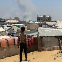 Illustrative: A Palestinian child looks on as smoke billows in the distance following a bombardment in Rafah, in the southern Gaza Strip on June 11, 2025. (AFP)