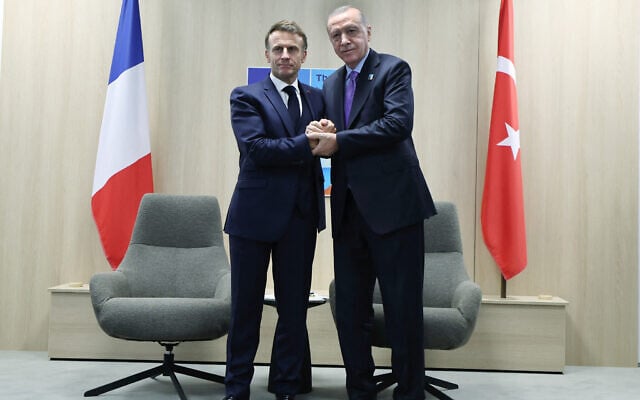 France's President Emmanuel Macron (L) shaking hands with Turkey's President Recep Tayyip Erdogan during their meeting on the sideline of the North Atlantic Treaty Organization (NATO) summit in The Hague, the Netherlands, June 25, 2025. (Photo by Handout / TURKISH PRESIDENTIAL PRESS SERVICE / AFP)