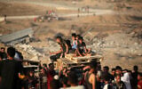 Illustrative: Children transporting wooden pallets ride along the Salah al-Din road near the Nuseirat refugee camp in the central Gaza Strip, used by food-seeking Palestinians to reach an aid distribution point set up by the Gaza Humanitarian Foundation (GHF), June 25, 2025. (Eyad BABA / AFP)