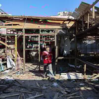 A Palestinian woman walks on debris at Al-Baqa cafeteria, which was devastated in an Israeli strike on the Gaza City seafront on June 30, 2025. (Omar AL-QATTAA / AFP)