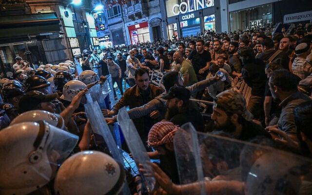 Islamist protesters clash with Turkish anti riot police officers as they gather to protest a cartoon supposedly depicting Islam's prophet Muhammad near LeMan Magazine in Istanbul on June 30, 2025. (Ozan KOSE / AFP)