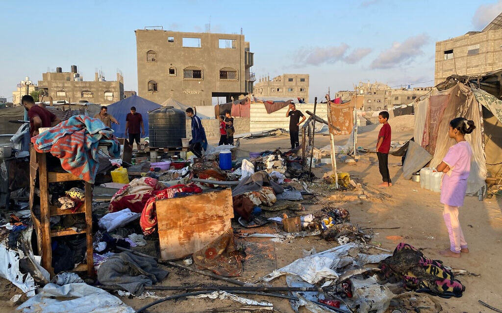 People inspect the damage after an Israeli strike on a camp housing displaced Palestinians in Khan Younis in the southern Gaza Strip on July 2, 2025 (AFP)