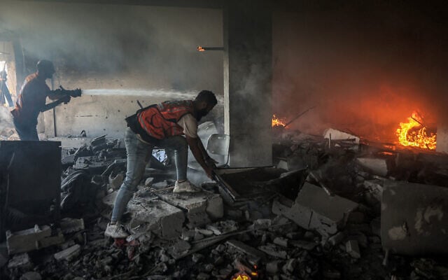 Members of the Hamas-linked civil defense try to extinguish a fire at a building hit by an Israeli strike in Gaza City in the central Gaza Strip, on July 2, 2025. (Omar Al-Qattaa/AFP) Members of the Hamas-linked civil defense try to extinguish a fire at a building hit by an Israeli strike in Gaza City in the central Gaza Strip, on July 2, 2025. (Omar Al-Qattaa/AFP)