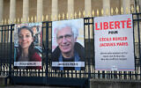 Portraits of French national Cecile Kohler (L) currently imprisoned in Iran with her partner French national Jacques Paris (C) along with a placard reading "Freedom for Cecile Kohler and Jacques Paris arbitrarily detained in Iran for over two years in appalling conditions" outside the Palais Bourbon, France's National Assembly, in Paris, on March 25, 2025. (Bertrand GUAY / AFP)