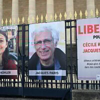Portraits of French national Cecile Kohler (L) currently imprisoned in Iran with her partner French national Jacques Paris (C) along with a placard reading "Freedom for Cecile Kohler and Jacques Paris arbitrarily detained in Iran for over two years in appalling conditions" outside the Palais Bourbon, France's National Assembly, in Paris, on March 25, 2025. (Bertrand GUAY / AFP)