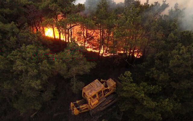 This handout picture released by the Syrian Arab News Agency's (SANA) telegram page shows a bulldozer attempting to contain a wildfire sweeping through Qatal Maaf in the Latakia province in Syria's Mediterranean West on July 4, 2025. (SANA / AFP) This handout picture released by the Syrian Arab News Agency's (SANA) telegram page shows a bulldozer attempting to contain a wildfire sweeping through Qatal Maaf in the Latakia province in Syria's Mediterranean West on July 4, 2025. (SANA / AFP)