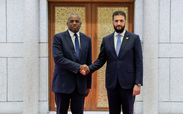 A handout picture released by the official Syrian Arab News Agency (SANA) shows Syria's interim President Ahmad al-Sharaa (R) welcoming with British Foreign Secretary David Lammy in the Syrian capital Damascus on July 5, 2025. (SANA / AFP)