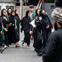 A Taliban security personnel stands guard as Afghan Shiite Muslim women march during a religious procession held to mark Ashura, on the tenth day of the Islamic holy month of Muharram, in Kabul on July 6, 2025. (Photo by Wakil KOHSAR / AFP)