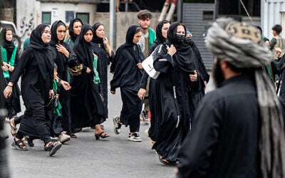 A Taliban security personnel stands guard as Afghan Shiite Muslim women march during a religious procession held to mark Ashura, on the tenth day of the Islamic holy month of Muharram, in Kabul on July 6, 2025. (Photo by Wakil KOHSAR / AFP) A Taliban security personnel stands guard as Afghan Shiite Muslim women march during a religious procession held to mark Ashura, on the tenth day of the Islamic holy month of Muharram, in Kabul on July 6, 2025. (Photo by Wakil KOHSAR / AFP)