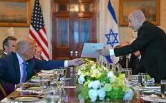Israeli Prime Minister Benjamin Netanyahu (R) hands over a letter to US President Donald Trump as they meets at the Blue Room of the White House in Washington, DC, on July 7, 2025.  (Photo by ANDREW CABALLERO-REYNOLDS / AFP)