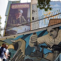 Pedestrians walk past a mural at Palestine Square in central Tehran on July 8, 2025, as an anti-Israeli billboard is displayed on the facade of a building depicting the Prime Minister Benjamin Netanyahu with text in Persian and Hebrew reading "Netanyahu lost another war; you fell victim to Bibi's political games; Where will the next failure to stay in power occur?" (AFP)
