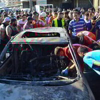 Paramedics inspect a burned vehicle that was targeted in an Israeli airstrike, in the Ayrouniyeh area near Lebanon's northern port city of Tripoli, July 8, 2025. (Fathi AL-MASRI / AFP)