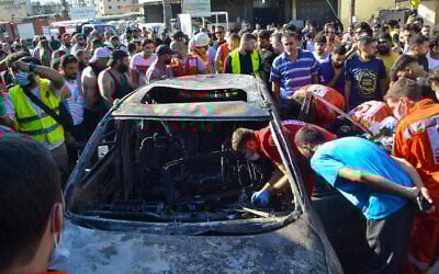 Paramedics inspect a burned vehicle that was targeted in an Israeli airstrike, in the Ayrouniyeh area near Lebanon's northern port city of Tripoli, July 8, 2025. (Fathi AL-MASRI / AFP)