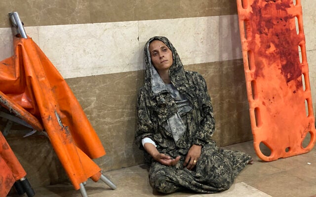 A Palestinian woman, wounded in an Israeli strike near Khan Yunis, sits on the floor at the Nasser Hospital in the southern Gaza Strip city late on July 8, 2025. (Photo by AFP)