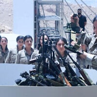 Fighters with the Kurdistan Workers' Party (PKK) line up to put their weapons into a pit during a ceremony in Sulaimaniyah, in Iraq's autonomous Kurdistan region, on July 11, 2025. (Shwan MOHAMMED / AFP)