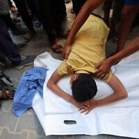 A Palestinian boy bids farewell to his cousin Saraj Ibrahim, after he was killed in an Israeli strike that hit Nuseirat in the central Gaza Strip on July 13, 2025 (Eyad BABA / AFP)