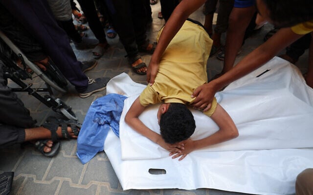 A Palestinian boy bids farewell to his cousin Saraj Ibrahim, after he was killed in an Israeli strike that hit Nuseirat in the central Gaza Strip on July 13, 2025 (Eyad BABA / AFP)