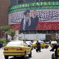 Motorists drive their vehicles past a billboard depicting Iran's Supreme Leader Ayatollah Ali Khamenei, in the center of Tehran's Valiasr Square, on July 13, 2025. (ATTA KENARE / AFP)
