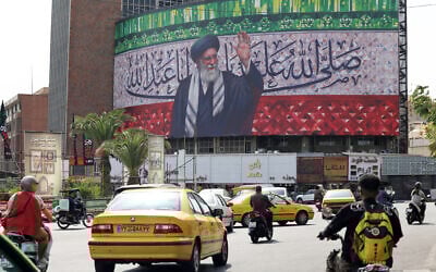 Illustrative: Motorists drive their vehicles past a billboard depicting Iran's Supreme Leader Ayatollah Ali Khamenei, in the center of Tehran's Valiasr Square, on July 13, 2025. (ATTA KENARE / AFP)