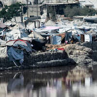 Encampments sheltering Palestinians displaced by conflict are pitched near the Sheikh Radwan wastewater collection pond, which is nearing its filling capacity, in Gaza City on July 14, 2025. (Bashar TALEB / AFP)