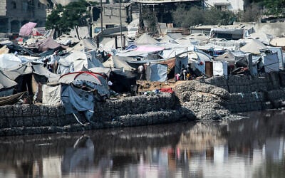 Encampments sheltering Palestinians displaced by conflict are pitched near the Sheikh Radwan wastewater collection pond, which is nearing its filling capacity, in Gaza City on July 14, 2025. (Bashar TALEB / AFP)