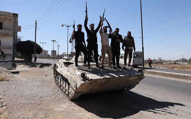 Syria's security forces stand on a tank in the predominantly Druze city of Sweida on July 15, 2025, following clashes between Bedouin tribes and Druze fighters.  (Photo by Bakr ALkasem / AFP)