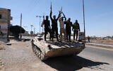 Members of Syria's security forces stand on a tank in the predominantly Druze city of Sweida on July 15, 2025, following clashes between Bedouin tribes and Druze fighters.  (Bakr Alkasem / AFP)