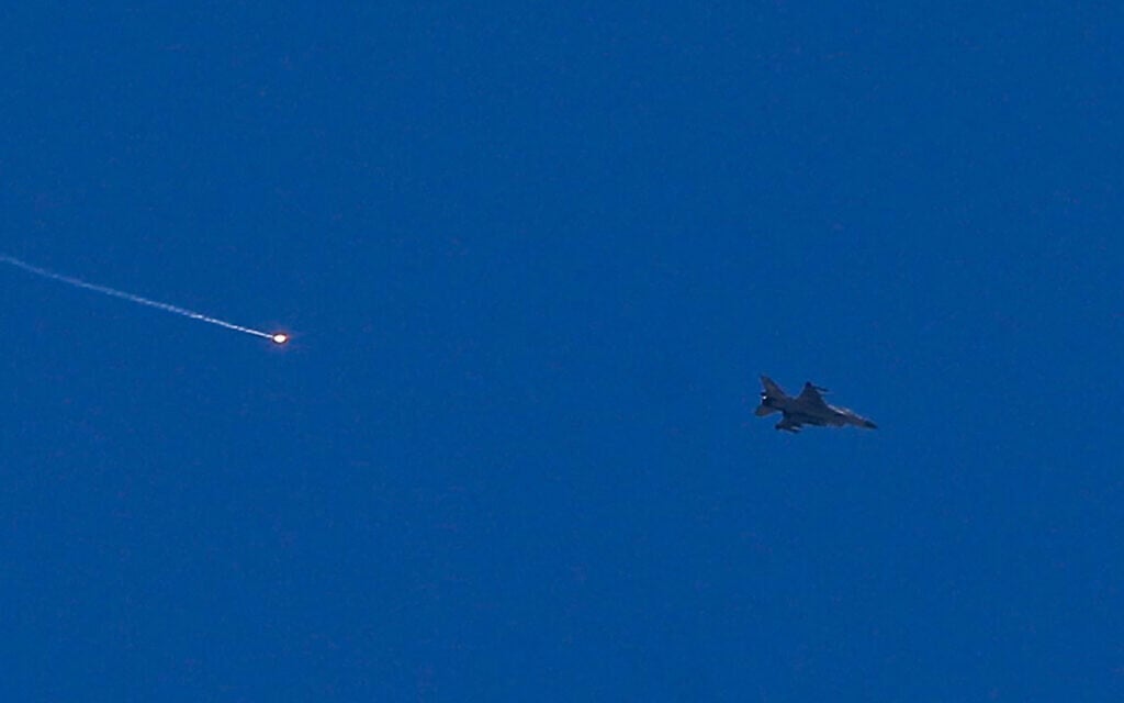 An Israeli fighter aircraft fires a flare as it flies over the predominantly Druze city of Sweida on July 15, 2025, following clashes between Bedouin tribes and Druze fighters. (Photo by Bakr ALKASEM / AFP)