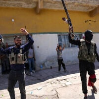 Members of Syria's security forces and children holding rifles celebrate in the predominantly Bedouin-inhabited al-Mouqawwas neighbourhood in Sweida on July 15, 2025, following clashes between Bedouin tribes and Druze fighters. (Photo by Bakr ALKASEM / AFP)