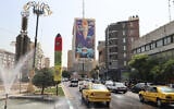 Traffic flows in Tehran past a huge billboard bearing a painting of a missile falling on Israel with the slogan in Farsi, "The missile has fallen amidst the demons," on July 16, 2025 (ATTA KENARE / AFP)