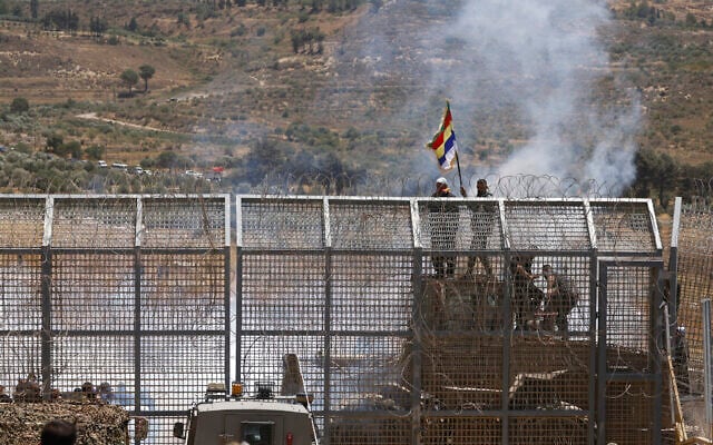 Isaeli troops take measures to stop Druze Syrians from crossing the dividing line into the Golan Heights, near Majdal Shams on July 16, 2025(Photo by Jalaa MAREY / AFP)
