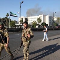 Syrian security forces stand guard in front of the heavily damaged Syrian army and defense ministry headquarters complex in Damascus, following Israeli strikes on July 16, 2025. (Bakr Alkasem/AFP)