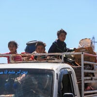 Bedouin residents leave in trucks loaded with their belongings, in the vicinity of the Druze al-Mazraa village in Syria's southern Sweida governorate on July 17, 2025, seeking safer areas amid ongoing clashes. (Bakr ALKASEM / AFP)