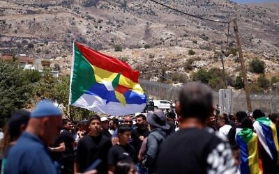 Druze wait near the border fence in the Golan Heights village of Majdal Shams, as Syrian Druze who had crossed over the day before cross back to return to Syria, on July 17, 2025. (Jalaa MAREY / AFP)