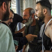 A Druze Syrian man, wounded in the latest rounds of fighting, is surrounded by friends and family members following the withdrawal of government forces from Syria's southern Sweida city on July 17, 2025. (Shadi AL-DUBAISI / AFP)