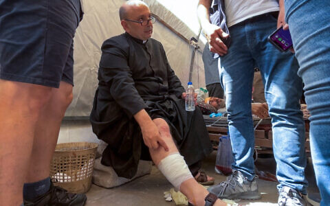 Parish Priest of the Holy Family church in Gaza City Fr. Gabriel Romanelli receives care after he was injured in an alleged Israeli strike on the church on July 17, 2025. (Omar AL-QATTAA / AFP)