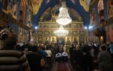 Christian Palestinian mourners attend the funeral ceremony of Saad Salameh and Foumia Ayyad, killed earlier in an Israeli strike that hit the Holy Family church in Gaza City, as Archbishop Alexios of the Saint Porphyrius Church leads the mass on July 17, 2025. (Omar al-Qattaa/AFP)