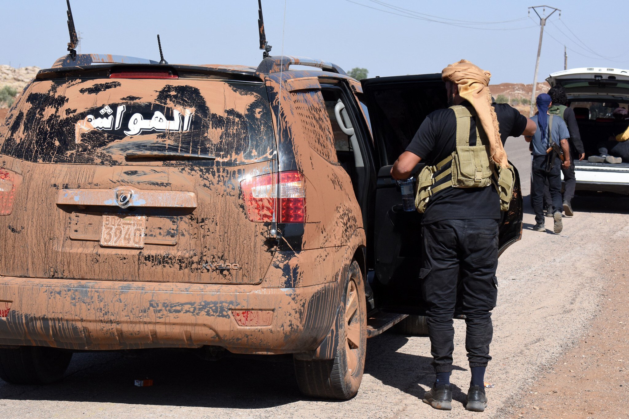 Fighters from Bedouin tribes gather near camouflaged vehicles along a road in al-Mazraa village leading to the predominantly Druze city of Sweida in southern Syria on July 18, 2025 (AFP Photo)