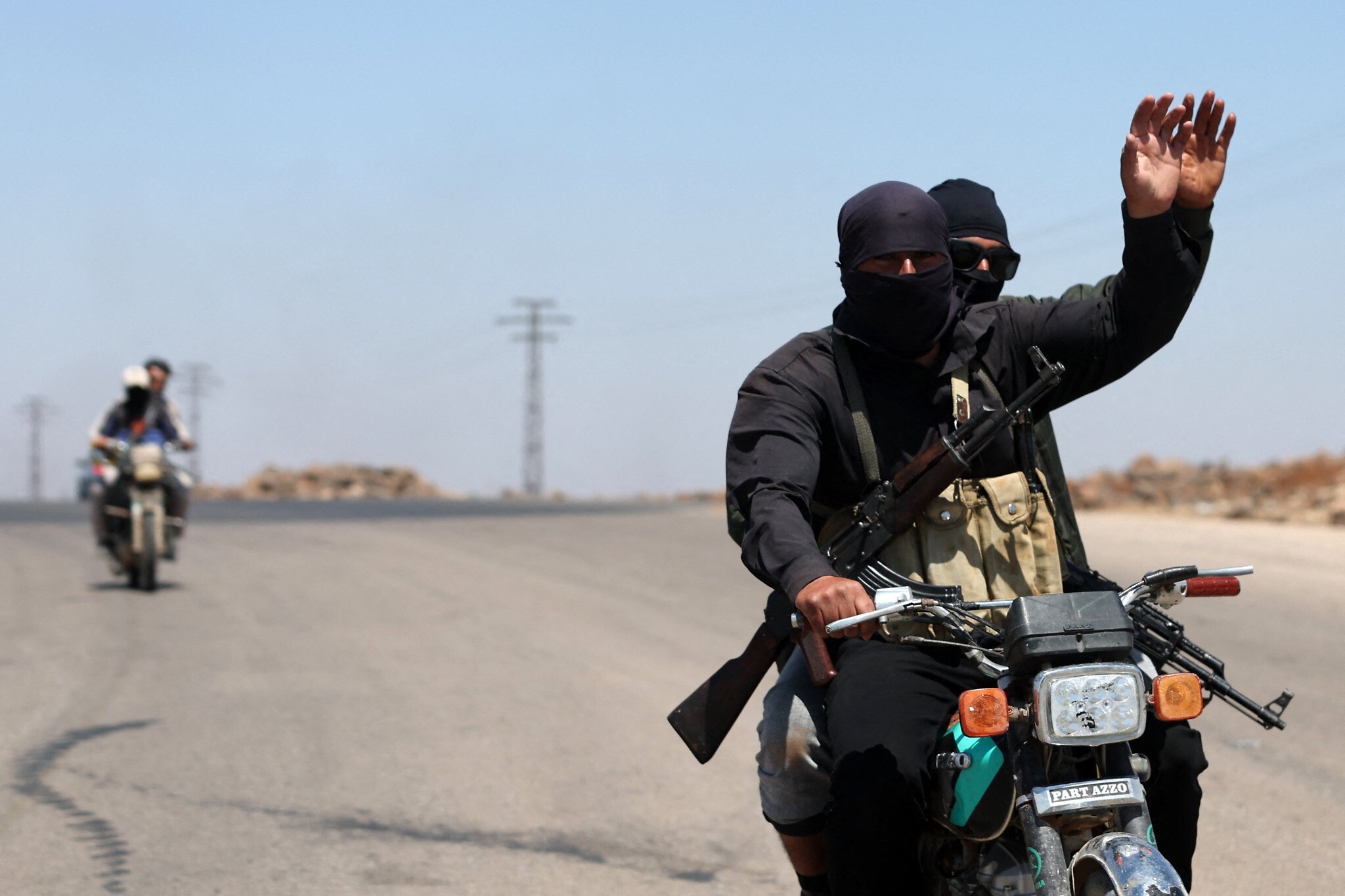 Fighters from Bedouin tribes ride motorcycles along a road in al-Mazraa village in Syria’s southern Sweida governorate, as clashes with Druze gunmen continue on July 18, 2025 (AFP)
