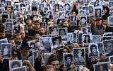 People hold pictures of victims during a ceremony to commemorate the 31st anniversary the Mutual Israelite Association of Argentina (AMIA) terror bombing, which killed 85 and wounded more than 300, in Buenos Aires on July 18, 2025. (Luis Robayo/AFP)