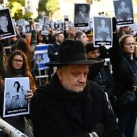 People hold pictures of victims during a ceremony to commemorate the 31st anniversary the AMIA bombing attack which left 85 dead and more than 300 wounded, in Buenos Aires, Argentina, on July 18, 2025. (Luis ROBAYO / AFP)