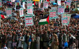 Yemenis lift placards and Palestinian flags during a rally against Israel and the United States, in the Houthi-run capital Sanaa on July 18, 2025. (Mohammed Huwais/AFP)