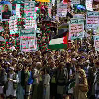 Yemenis lift placards and Palestinian flags during a rally against Israel and the United States, in the Houthi-run capital Sanaa on July 18, 2025. (Mohammed Huwais/AFP)
