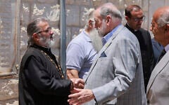 US Ambassador to Israel Mike Huckabee (C) shakes hands with Father Daoud Khoury of the Greek Orthodox Church during his visit to the Christian Palestinian village of Taybeh in the West Bank on July 19, 2025. (Jaafar Aashtityeh/AFP)