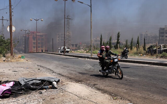 Bodies lie on the ground as Bedouin and tribal fighters drive along a street amid a cloud of smoke in the northern part of the city of Sweida in southern Syria's Druze majority province on July 19, 2025 (Bakr ALkasem / AFP) Bodies lie on the ground as Bedouin and tribal fighters drive along a street amid a cloud of smoke in the northern part of the city of Sweida in southern Syria's Druze majority province on July 19, 2025 (Bakr ALkasem / AFP)