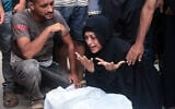A Palestinian woman mourns over the body of a man said to have been killed near a food distribution center run by the Gaza Humanitarian Foundation, a US- and Israel-backed organization, at the Nasser hospital on July 19, 2025 (AFP)