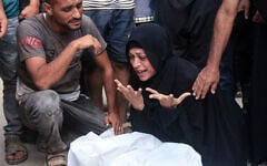 A Palestinian woman mourns over the body of a man said to have been killed near a food distribution center run by the Gaza Humanitarian Foundation, a US- and Israel-backed organization, at the Nasser hospital on July 19, 2025 (AFP)