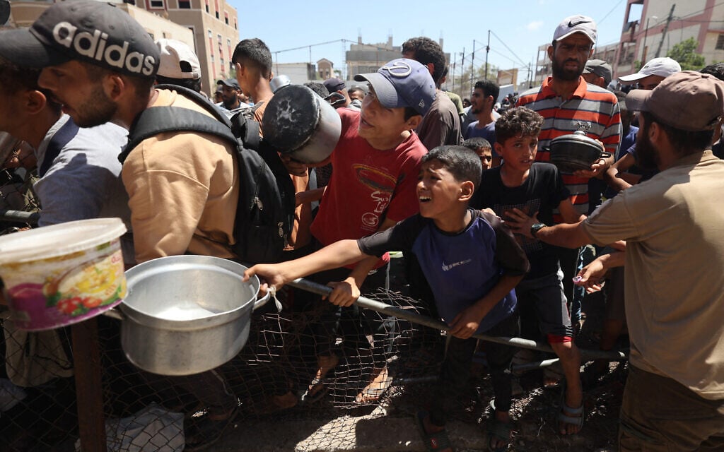 Palestinians gather at a food distribution point in the Nuseirat refugee camp in the central Gaza Strip on July 19, 2025 (Eyad BABA / AFP)