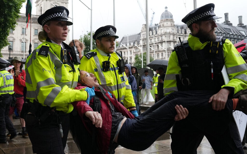 A protester is carried away by police officers at a demonstration in support of the proscribed group Palestine Action calling for the recently imposed ban to be lifted, in Parliament Square, central London, on July 19, 2025 (CARLOS JASSO / AFP)