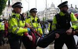 A protester is carried away by police officers at a demonstration in support of the proscribed group Palestine Action calling for the recently imposed ban to be lifted, in Parliament Square, central London, on July 19, 2025 (Carlos Jasso / AFP)